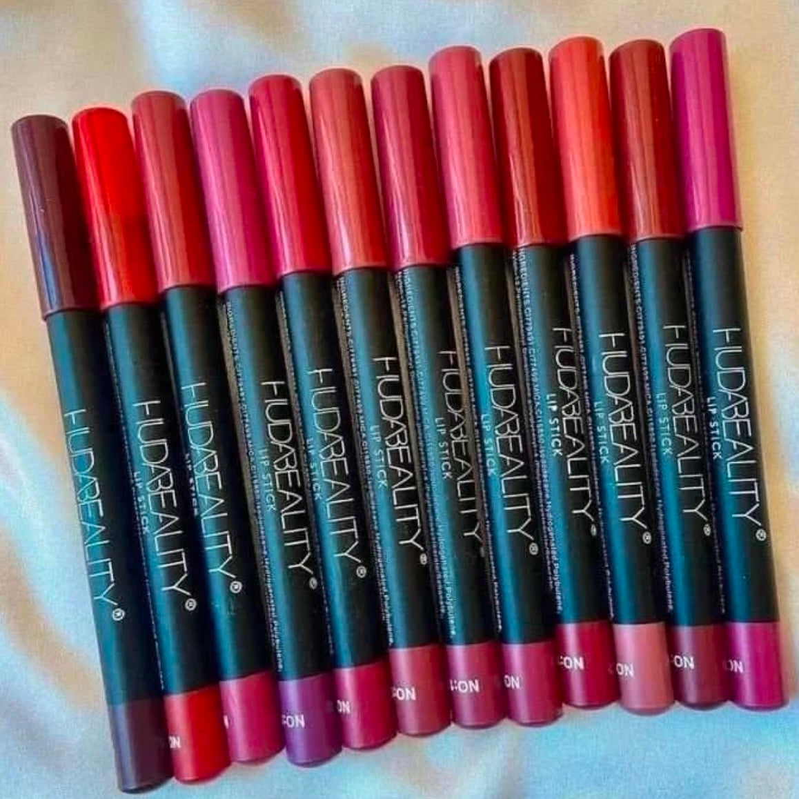 Huda Beauty Jumbo Matte Lip Liners in a pack of 12, showcasing various shades in sleek pencil form.